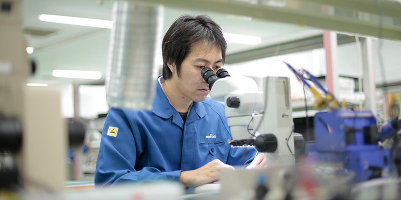 材料開発(有機・高分子)職に就く社員が顕微鏡を覗いている様子