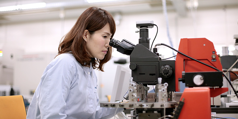分析・評価技術職に就く社員が顕微鏡を覗いている様子