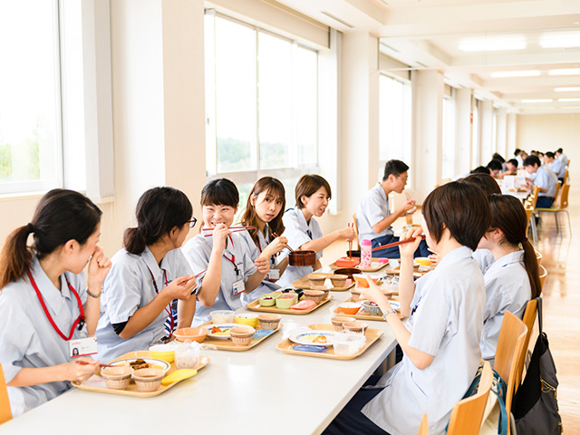 食堂で女性社員が昼食をとっている様子